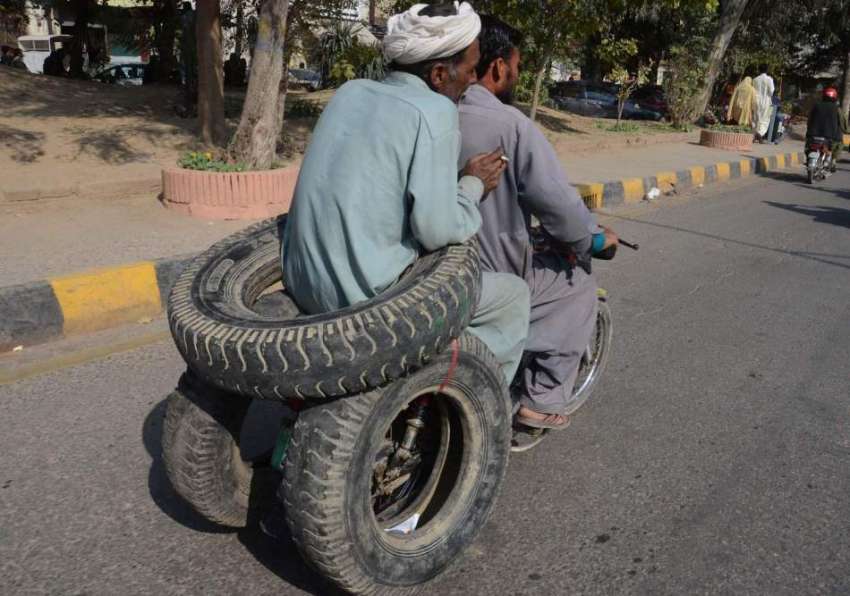 لاہور: ایک شخص خطر ناک انداز سے موٹر سائیکل پر ٹائر رکھے ..
