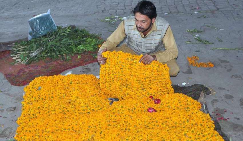 لاہور: ایک دکاندار فروخت کے لیے پھولوں کی پتیاں سجا رہا ہے۔