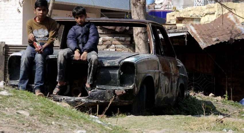 راولپنڈی: رتہ امرال ورکشاپ میں موجود ایک پرانی گاڑی پر بیٹھے ..