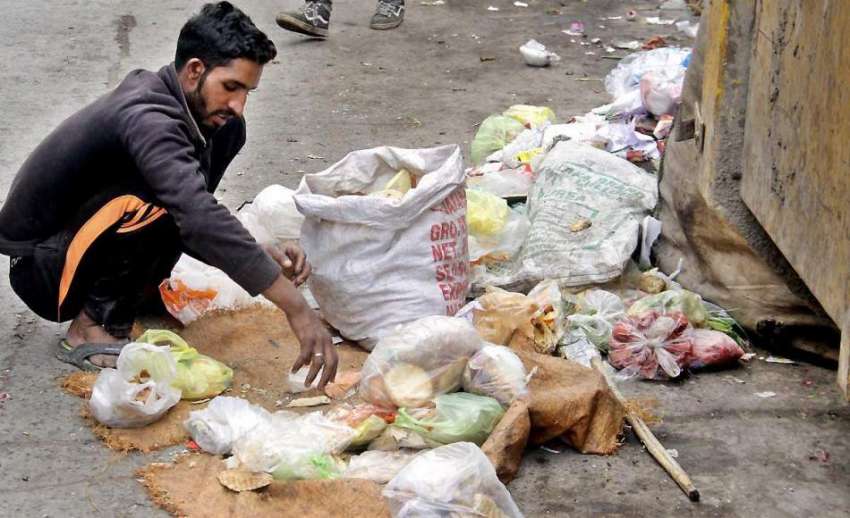 لاہور: ایک شخص کچرے کے ڈھیر سے کار آمد اشیاء تلاش کر رہا ہے۔