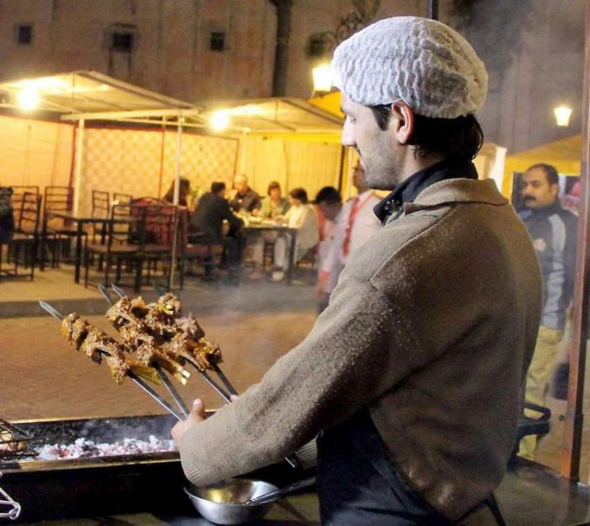 لاہور: فوڈ سٹریٹ میں ایک کاریگر باربی کیو تیار کررہا ہے۔