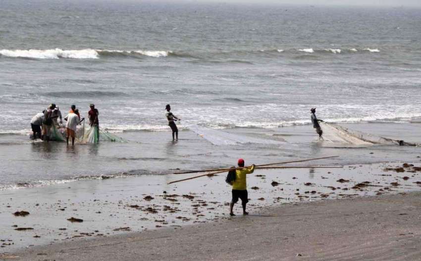 کراچی: ماہی گیر مچھلیاں پکڑنے کے لیے سمندر میں جال پھینک ..