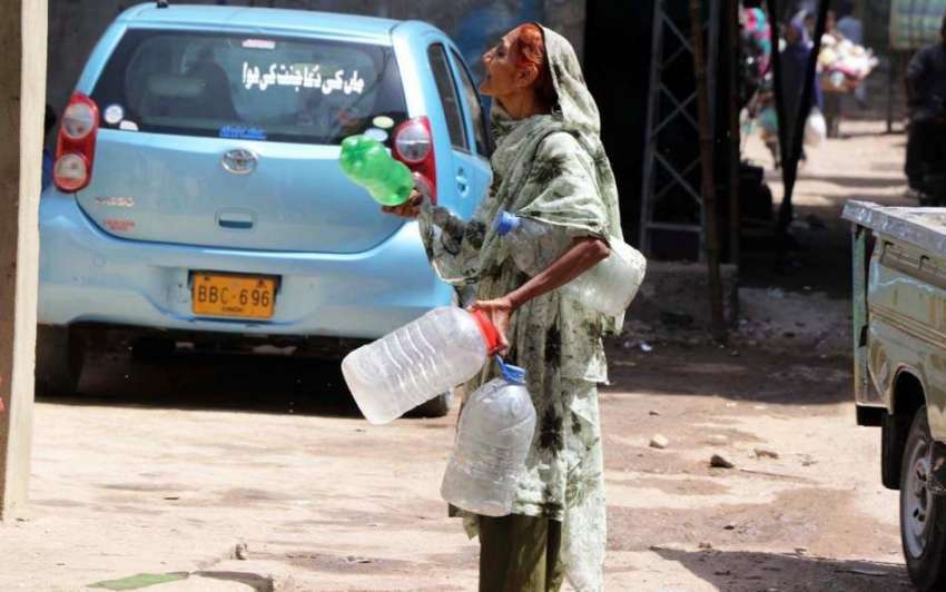 کراچی: ایک معمر خاتون پانی کی قلعت کے باعث خالی بوتلیں اٹھائے ..