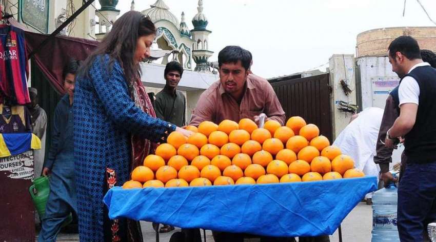 راولپنڈی: ایک خاتون ریڑھی بان سے پھل خرید رہی ہے۔