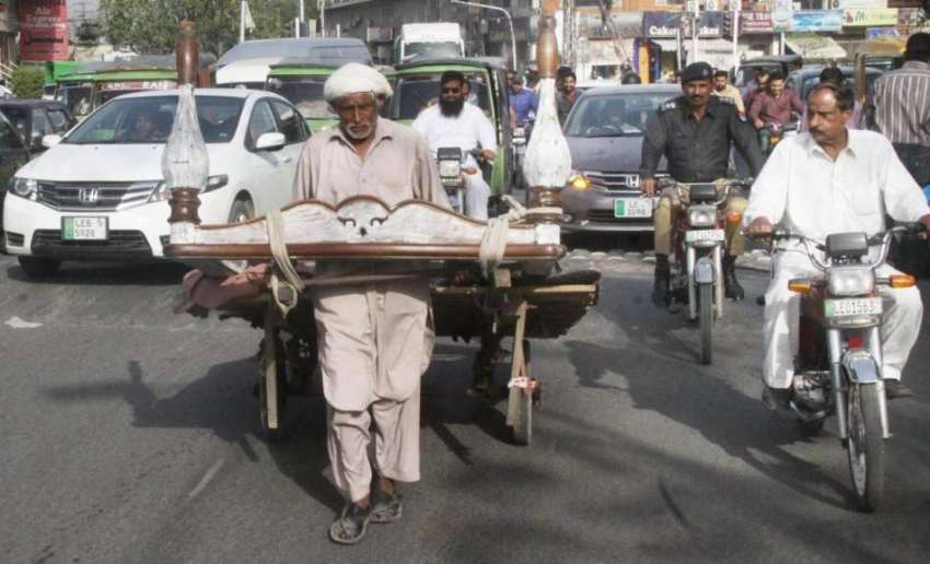 لاہور: ایک بزرگ ہتھ ریڑھی پر فرنیچر رکھے پریس کلب کے سامنے ..