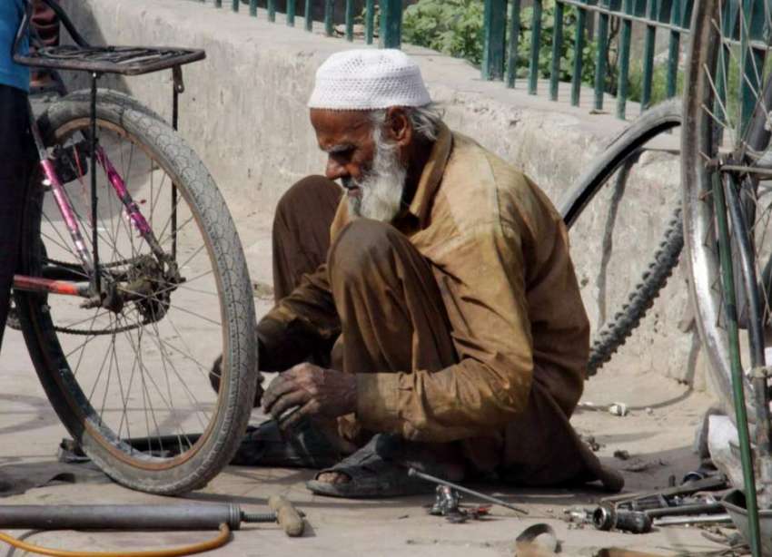 لاہور: ایک بزرگ کاریگر نیلا گنبد میں پرانی سائیکل مرمت کررہا ..