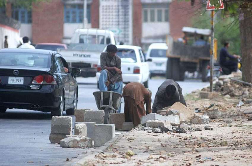 اسلام آباد: مزدور سیکٹر جی 7میں فٹ پاتھ کے تعمیراتی کام میں ..