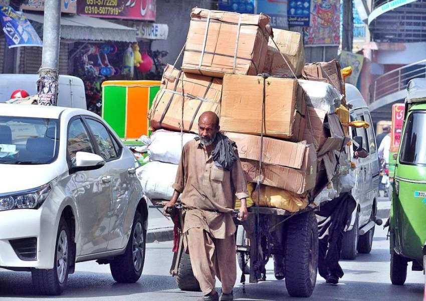 راولپنڈی: ایک محنت کش ہتھ ریڑھی پر بھاری سامان رکھے جا رہا ..