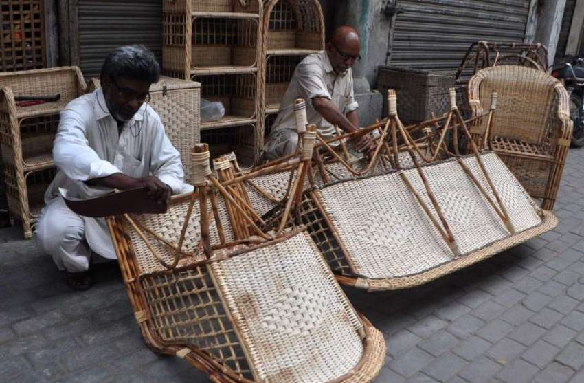 لاہور: دو محنت کش لکڑی کی کرسیاں بننے میں مصروف ہیں۔