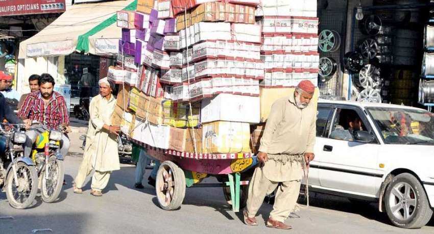راولپنڈی: محنت کش ریڑھی پر سامان لادے مری روڈ سے گزر رہا ..