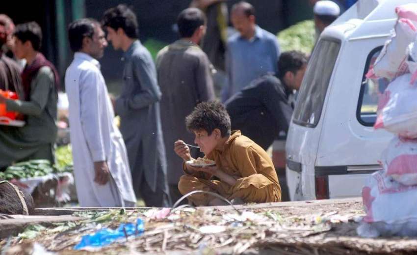 اسلام آباد: سبزی منڈی میں سخت محنت کے بعد ایک بچے کھانا کھا ..