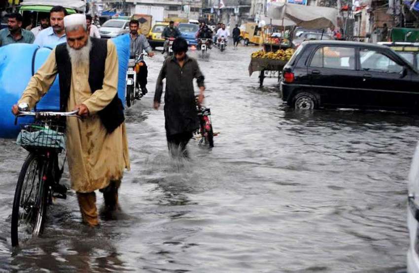 راولپنڈی: امام باڑہ چوک میں بارش کے بعد کھڑے پانی سے لوگ ..