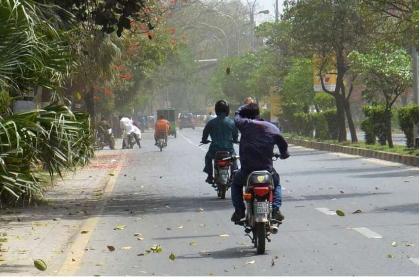 لاہور: موٹر سائیکل سوار شدید آندھی کے دوران ڈیوس روڈ سے گزر ..