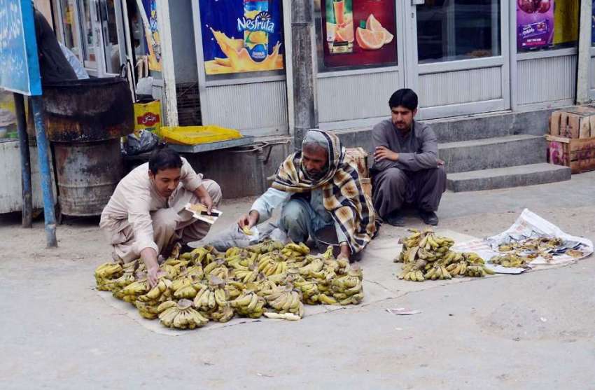 کوئٹہ: سورج گنج بازار میں ایک محنت کش زمن پر کیلے سجائے فروخت ..