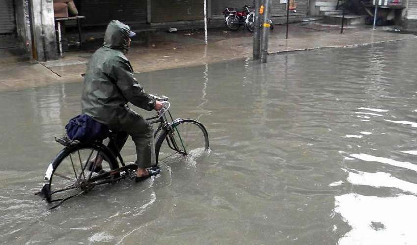 راولپنڈی: سائیکل سوار بارش کے پانی سے گزر رہا ہے۔