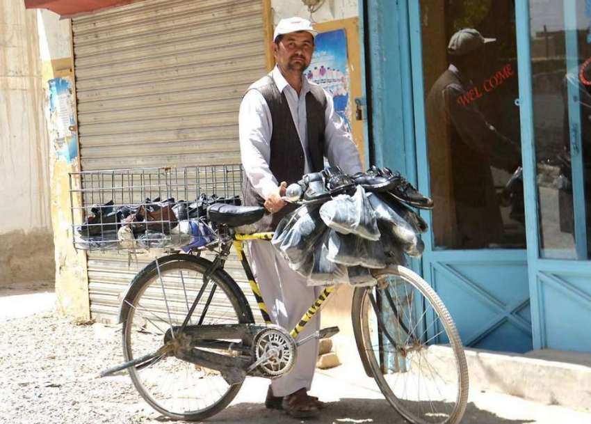 کوئٹہ: ایک محنت کش سائیکل پر جوتے فروخت کر رہا ہے۔