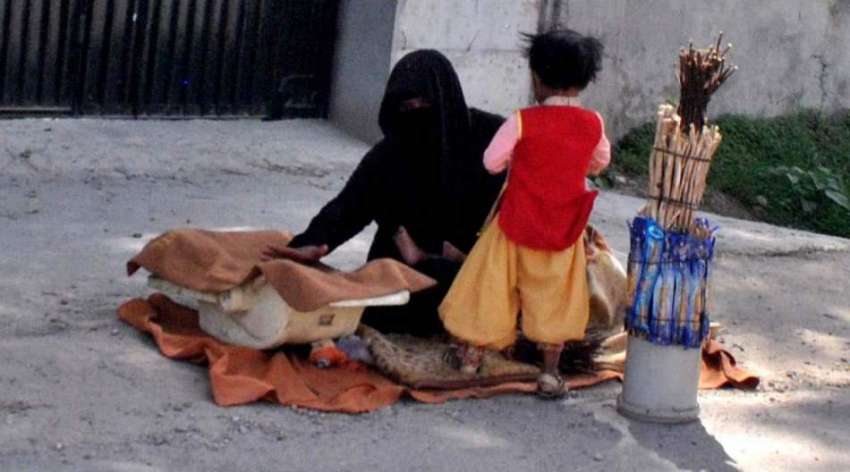 راولپنڈی: مری روڈ پر ایک خاتون اپنی بچی کے ہمراہ مسواک بیچ ..