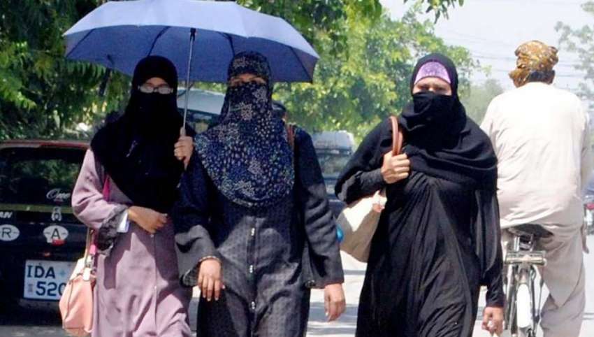 راولپنڈی: دھوپ کی شدت سے بچنے کے لیے طالبات چھتری تانے جا ..
