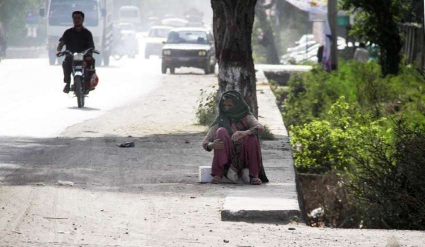 اسلام آباد: ایک بزرگ خاتون مٹی سے بچنے کے لیے منہ پر کپڑا ..