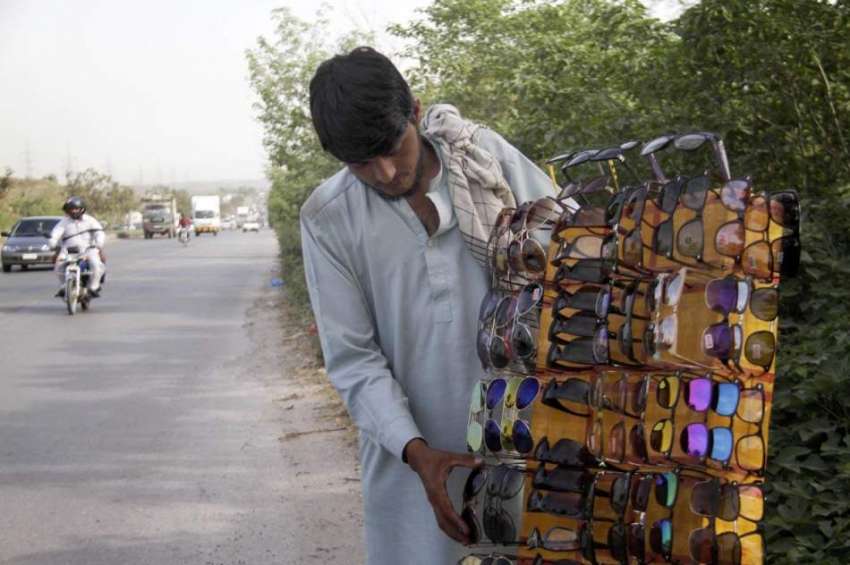 اسلام آباد: ایک محنت کش سڑک کنارے عینکوں کا سٹال لگائے گاہکوں ..