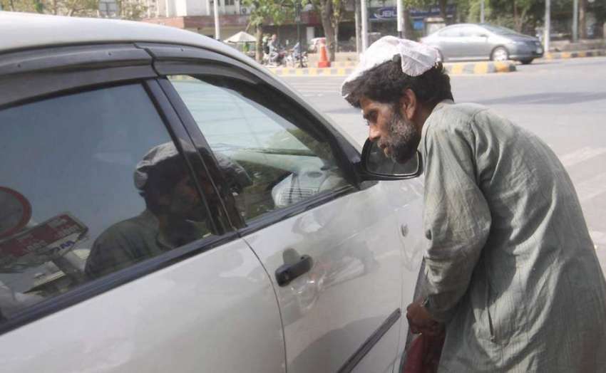 لاہور: ایک بھیکاری ٹریفک سگنل پربھیک مانگ رہا ہے۔