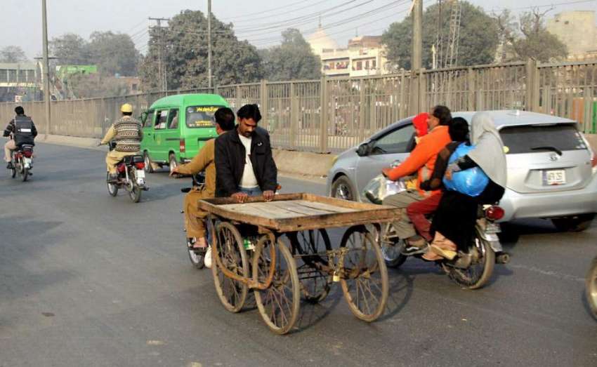 لاہور:موٹر سائیکل سوار ہتھ ریڑھی کو لیے جارہے ہیں جوکسی ..