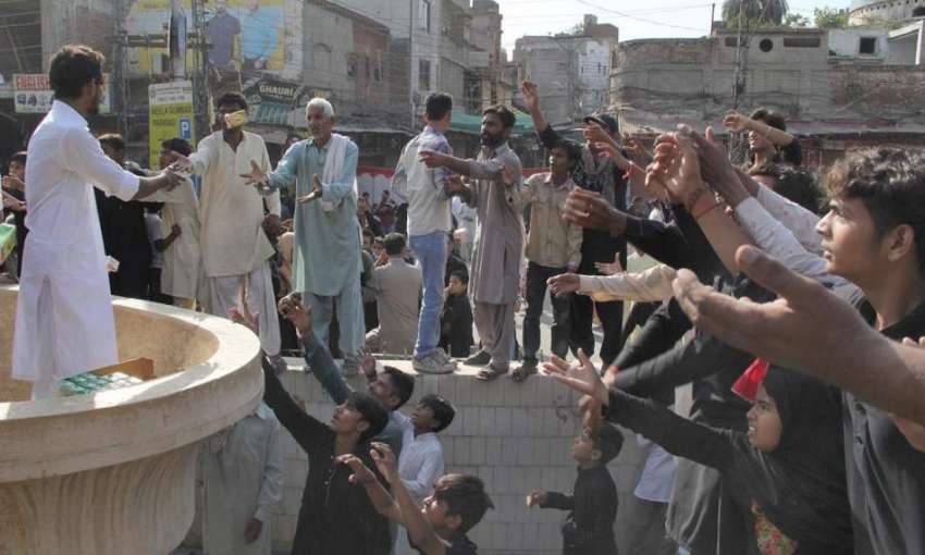 لاہور: یوم عاشور کے موقع پر ایک شخص جوس بانٹ رہا ہے۔