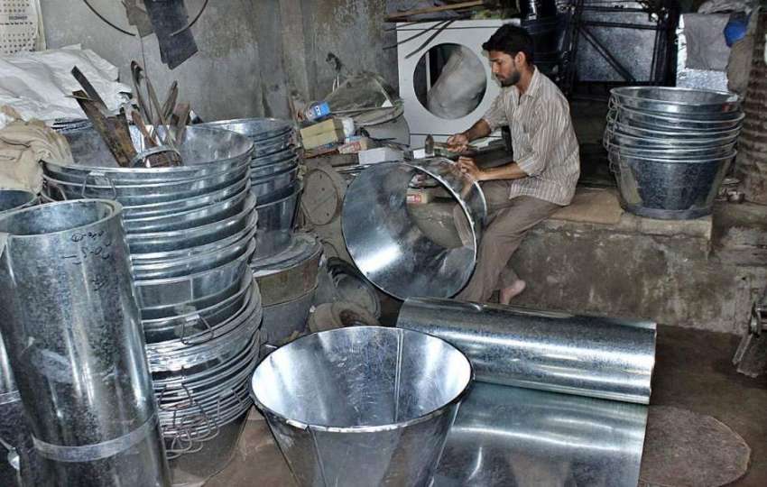 لاہور: مزدور اپنے ورکشاپ میں پانی کے ٹب بنانے میں مصروف ہے۔