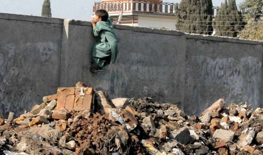 راولپنڈی: چمن زار کے علاقہ میں ایک خانہ بدوش بچہ دیوار پر ..