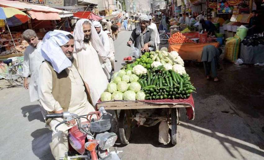 کوئٹہ: سبزی مارکیٹ میں شہری ایک ریڑھی بان سے سبزی خرید رہے ..