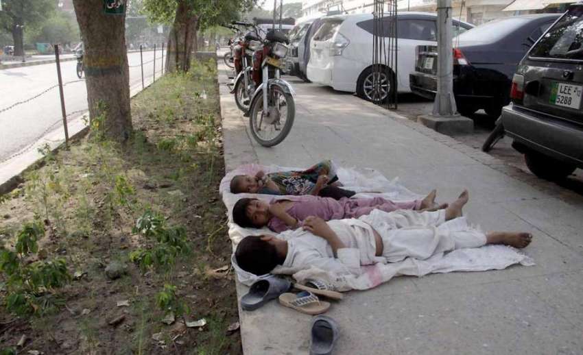 لاہور: مال روڈ پر فٹ پاتھ پر بچے درخت کی چھاؤں میں لیٹے ہوئے ..