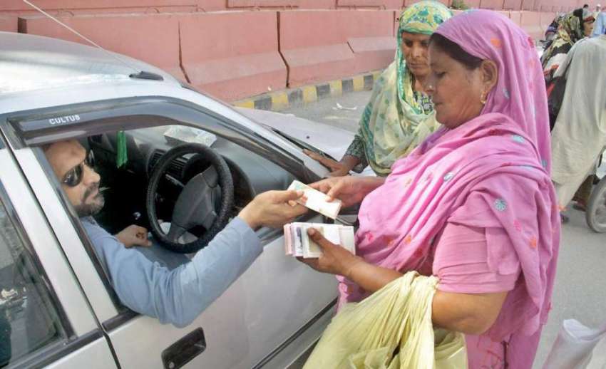 لاہور: ایک شہری عیدالفطر کے لیے اسٹیٹ بینک کے باہر خاتون ..