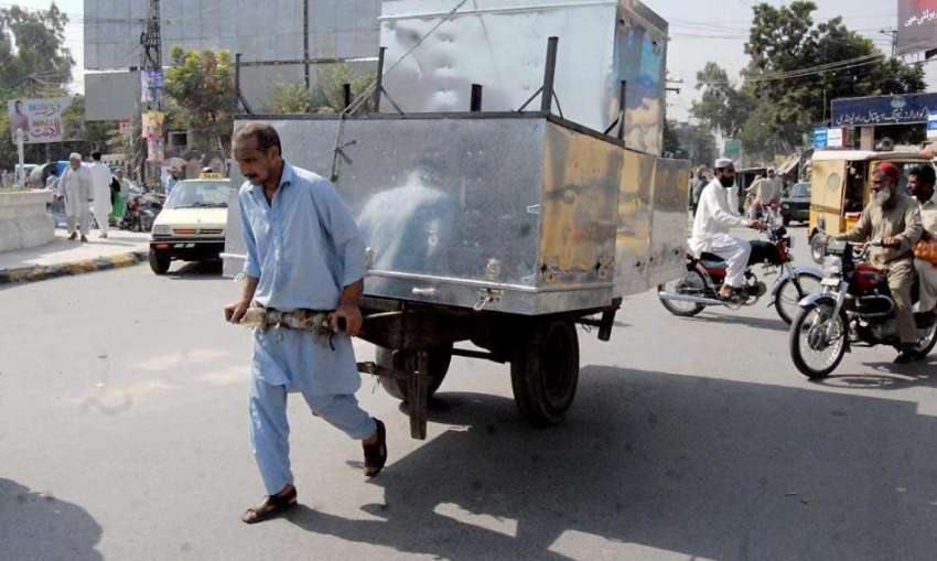 راولپنڈی: ایک محنت کش سامان سے لدا ہتھ ریڑھا کھینچے ہوئے ..