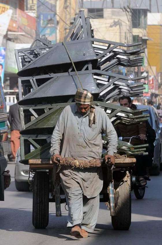 راولپنڈی: ایک مزدور ہتھ ریڑھی پر بھاری سامان رکھ کر لیجا ..