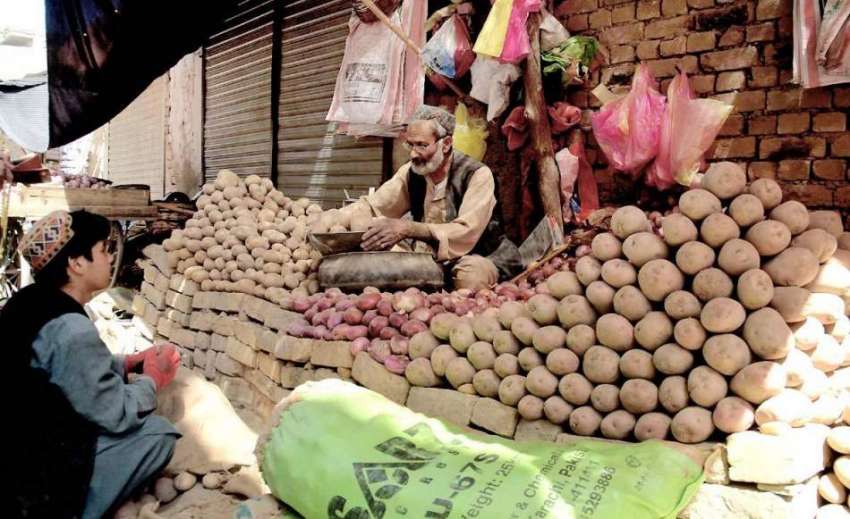 کوئٹہ: سبزی مارکیٹ میں ایک شخص اپنے اسٹال پر بیٹھا آلو پیاز ..