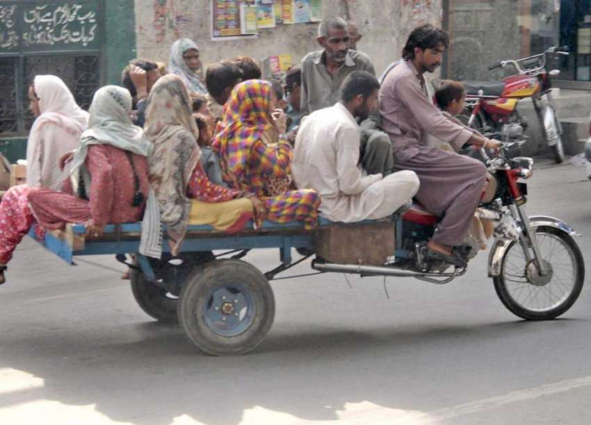 لاہور: ایک خانہ بدوش موٹر سائیکل رکشے پر اپنے کنبے کو بٹھا ..