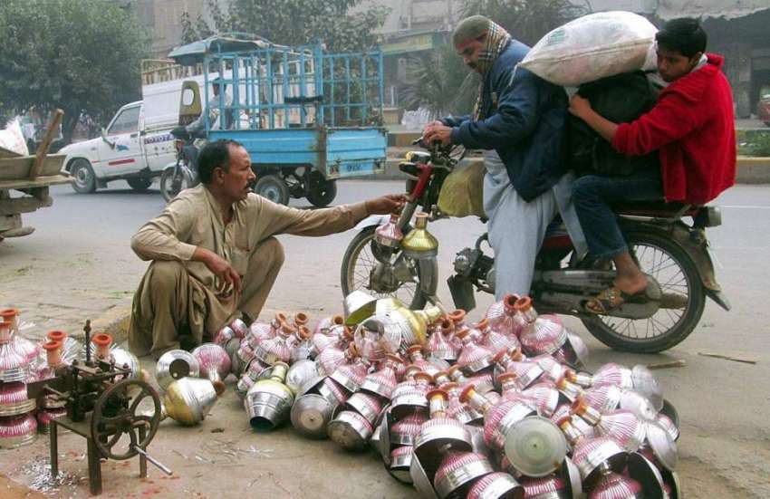 فیصل آباد: موٹر سائیکل سوار حکے کی چلم خرید رہے ہیں۔