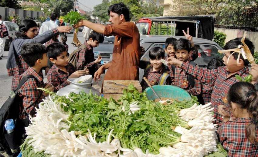 راولپنڈی: بچے ایک سلاد فروش سے مولیاں خرید رہے ہیں۔
