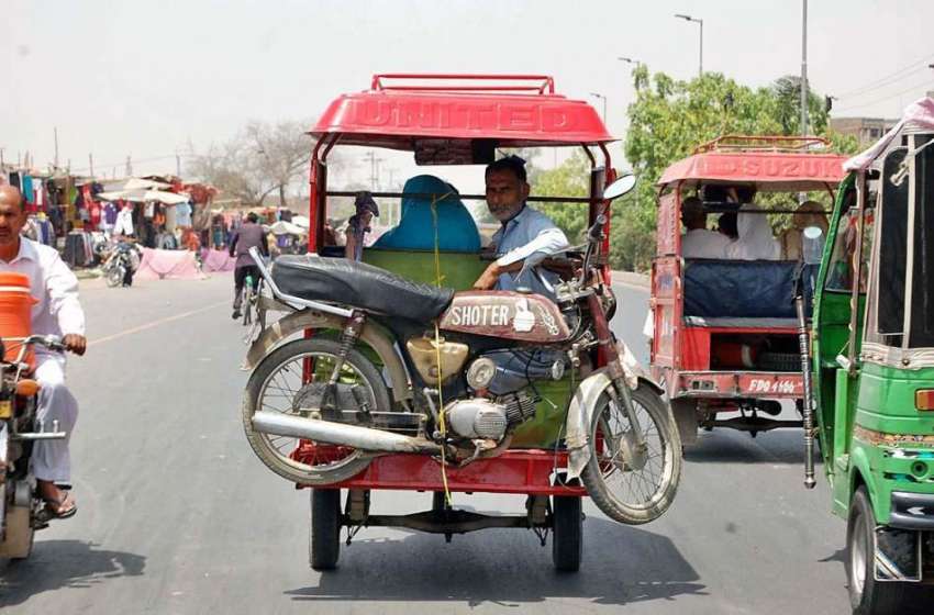 فیصل آباد: ایک چنگچی والا اپنی چنگچی پر موٹر سائیکل رکھ کر ..