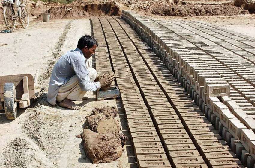 فیصل آباد: مزدور بھٹے پر اینٹیں بنا رہا ہے۔