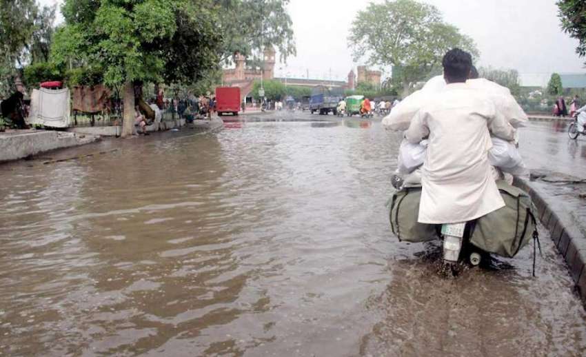 لاہور: موٹر سائیکل سوار شہری موسلا دھار بارش کے بعد ریلوے ..