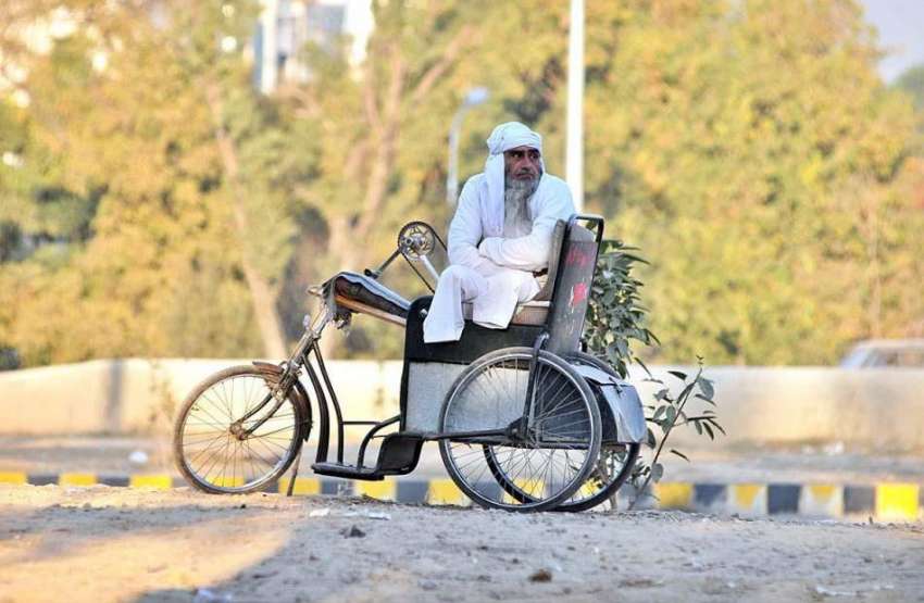 اسلام آباد: ایک معذور شخص سردی کی شدت سے بچنے کی لیے دھوپ ..