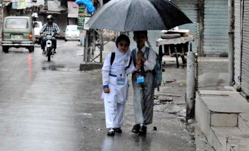 راولپنڈی: تعطیلات ختم ہونے کے بعد بچے بارش سے بچنے کے لیے ..