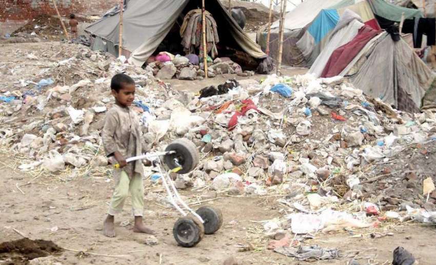 لاہور: ایک خانہ بدوش بچہ ٹوٹی سائیکل کے ساتھ کھیل رہا ہے۔