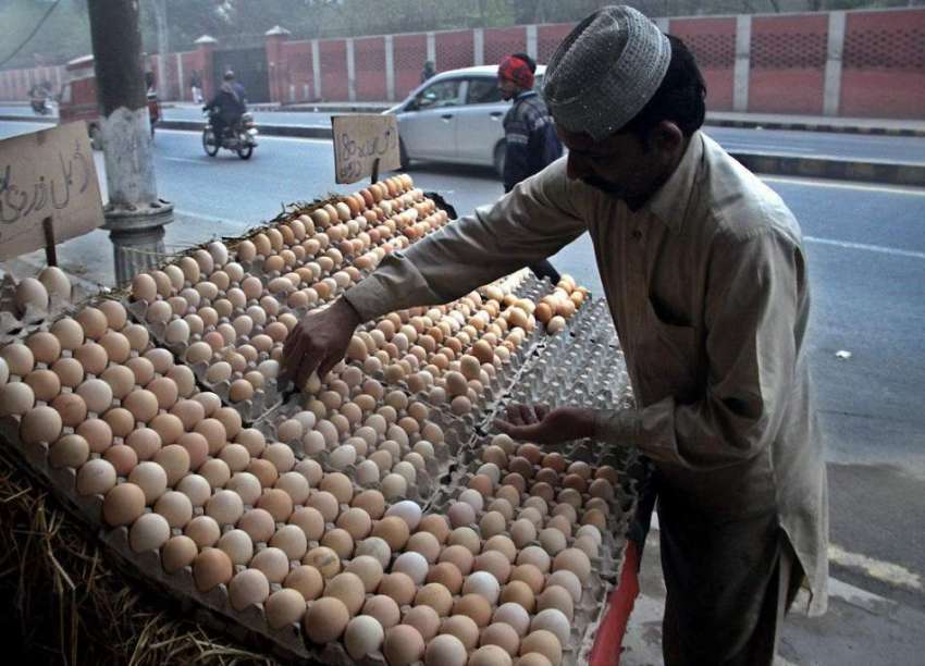 لاہور: ایک محنت کش سڑک کنارے انڈے فروخت کرنے کے لیے کھڑا ..