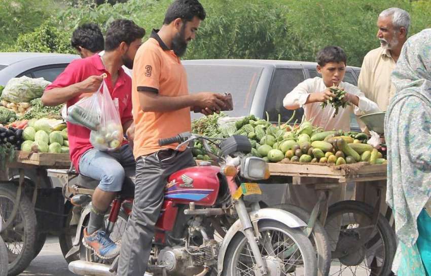 لاہور: شہری شادمان روڈ پر ریڑھی والے سے سبزی خرید رہے ہیں۔