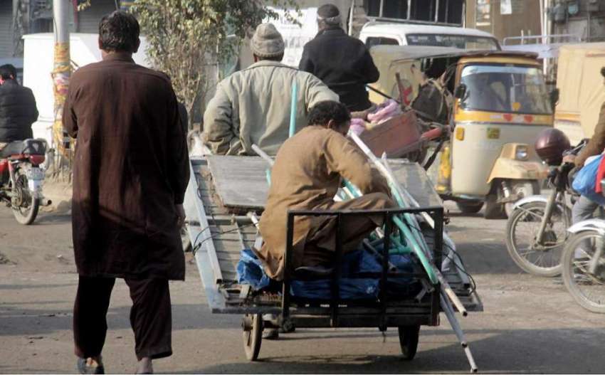 لاہور: مزدور ہتھ ریڑھی پر سامان اور اپنے ساتھی کو بٹھاکر ..