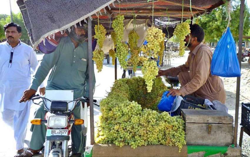 بہاولپور: شہری ریڑھی بان سے انگور خرید رہا ہے۔