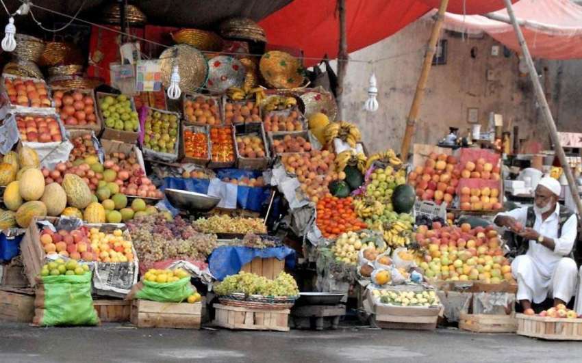 راولپنڈی: ایک دکاندار فروٹ فروخت کے لیے سجا رہا ہے۔