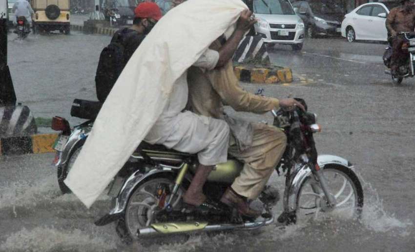 لاہور: شہر میں ہونیوالی موسلا دھار بارش کے دوران موٹر سائیکل ..